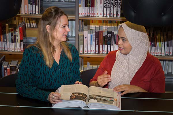 twee vrouwen bespreken boek in de bibliotheek